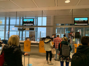 Passagiere stehen vor einem Flugschalter bereit ins Flugzeug einzusteigen